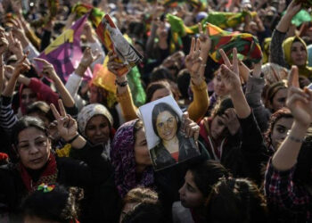 Kurdish people hold a picture of fighter during a celebration rally  near the Turkish-Syrian border at Suruc, in Sanliurfa province on January 27, 2015, who was killed in conflict with Islamic state militants in Kobani.  Kurdish fighters have expelled Islamic State group militants from the Syrian border town of Kobane, a monitor and spokesman said today, dealing a key symbolic blow to the jihadists' ambitions. AFP PHOTO/BULENT KILICBULENT KILIC/AFP/Getty Images